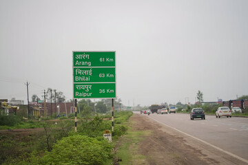 indian highway distance signboard bhilai aarang raipur, green road direction sign india, national highway travel guide board, rural expressway milestone signage stock photo.