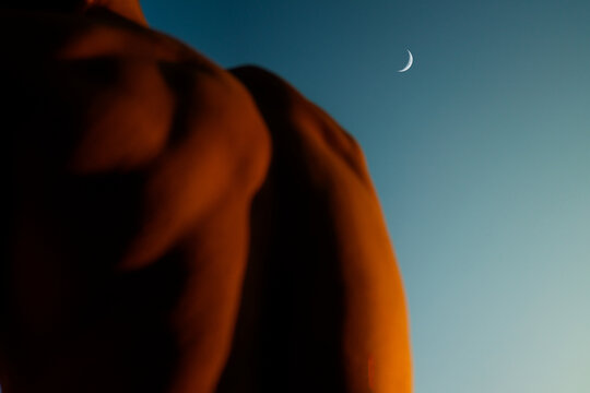 Muscular Back Silhouette Against Evening Sky With Crescent Moon