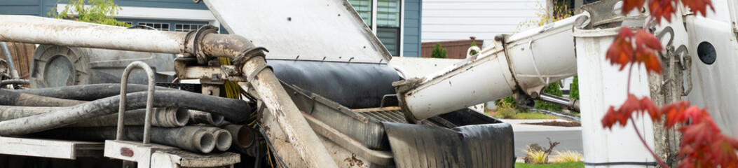 Cement mixer truck and cement pumper truck set up to feed fresh cement to boom arm to pump fresh...