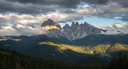 Dramatic Mountain Landscape: Sunlight Illuminates Peaks and Forest Below.
