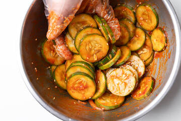 Korean cucumber salad (Oi muchim) mixing in bowl by hand, Korean side dish