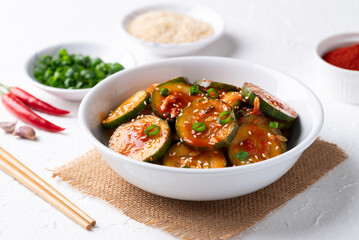 Korean cucumber salad (Oi muchim) in bowl on white background, Korean side dish