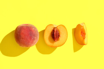 Sweet ripe peaches on yellow background