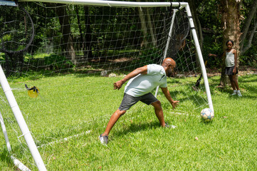 Goalkeeper Practices Soccer Skills in Backyard Setting During Daytime