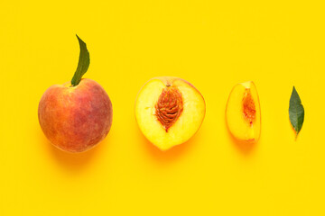 Sweet ripe peaches and leaves on yellow background