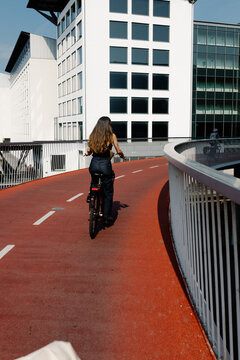 Woman riding a rental bike on an elevated bicycle path in Copenhagen