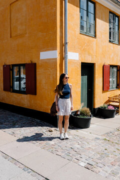 Tourist smiling and posing on a street corner in Nyboder, Copenhage