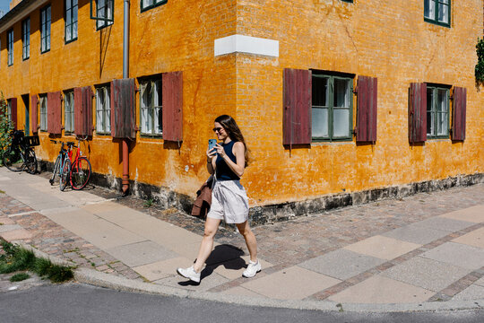 Happy tourist, taking pics with a mobile through the Nyboder district