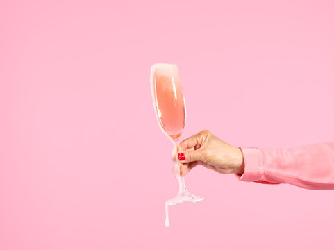 Woman Holding Overflowing Pink Champagne 