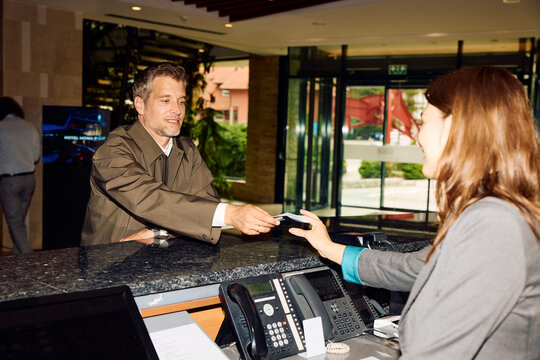 Man checks out at front desk in the hotel