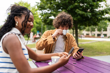 Students relaxing at outdoor purple table, drinking coffee