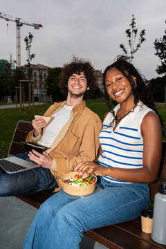 Young colleagues enjoying lunch break in a city park