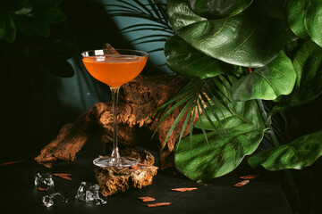 Orange cocktail drink with bourbon whiskey, bitters and lemon juice. Dusk background with old...