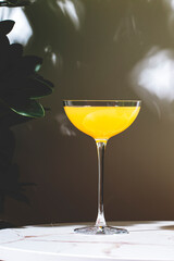 Monte Cassino, yellow alcoholic cocktail drink with whiskey, liqueur and lemon juice. Marble table...