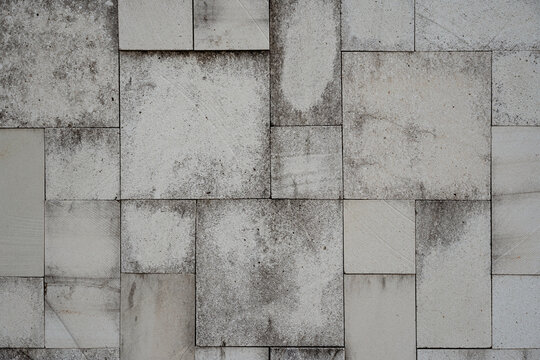 A weathered stone tile wall with a random rectangular pattern. This grunge, abstract texture makes for a perfect urban or industrial background.