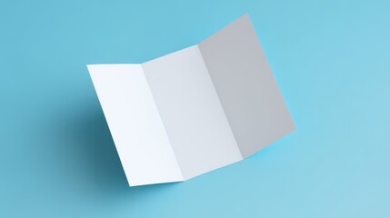 Unfolded three page white paper floats over light blue backdrop in the studio
