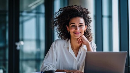 Experienced HR specialist coordinating diversity initiatives by evaluating talent acquisition reports and organizing targeted recruitment campaigns from a sleek office suite.