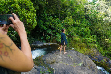 Tourists are visiting a beautiful, non-touristy waterfall on the outskirts of Whangarei., New Zealand.