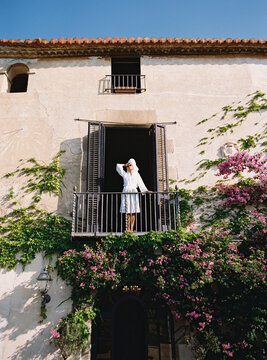Tourist enjoying morning sun on balcony of charming european hotel