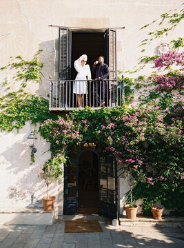 Couple enjoying morning coffee on balcony of picturesque italian villa