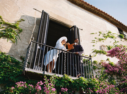 Couple enjoying morning coffee on balcony of picturesque italian villa