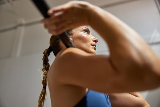 Woman lifting barbell in gym during strength training session