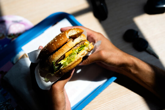Eating Freshly Made Burger on a Sunny Day Indoors