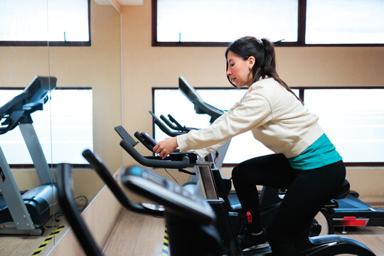 Young Woman Cycling on Stationary Bike Indoors