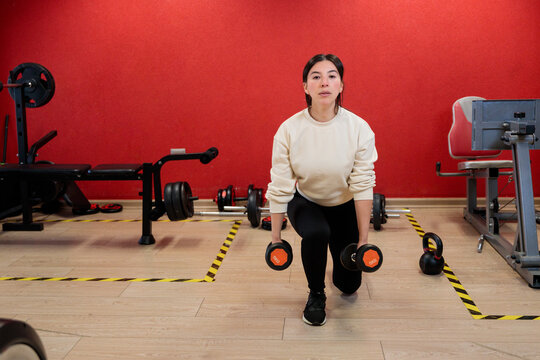 Woman Doing Dumbbell Lunges in Cozy Apartment Gym