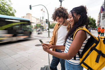 Tourists using smartphone app are waiting for bus at bus stop