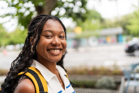 Young black student smiling in urban college campus with backpack