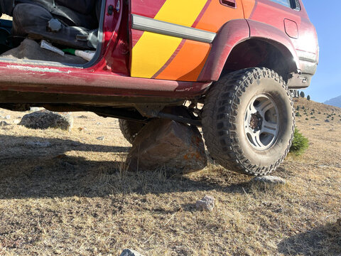 Off-road vehicle stuck on boulder