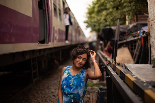 Indian woman standing by a running train 