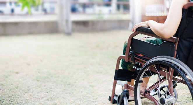 cropped shot, middle age female on wheelchair on grass field at home she resting after being sick