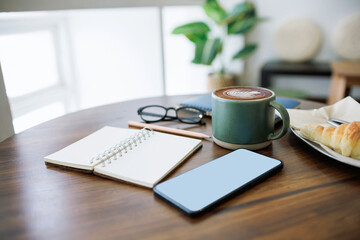 coffee drink and mobile phone, open note book for taking note with breakfast