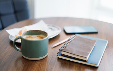 coffee drink and note book, diary for taking note with breakfast on wooden table