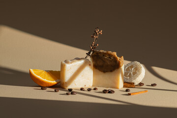 Artistic still life featuring natural soaps, fresh orange, and coffee