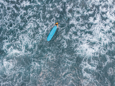Aerial View of Surfer Paddling in Ocean Waves