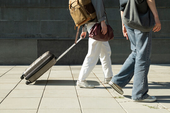 Tourists walking with luggage and backpack on a sunny day