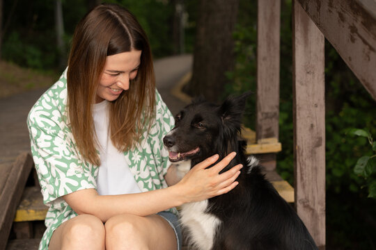 Woman Smiling and Petting Border Collie Dog
