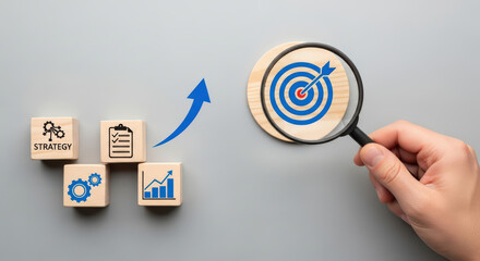 Strategic Business Growth and Development with Wooden Blocks Leading to a Target Under a Magnifying Glass Representing Planning, Analysis, and Achievement