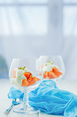 Fresh Apricot slices and Cream Dessert in brandy glasses, , topped with a creamy white sauce and sprinkled with crushed pistachios.