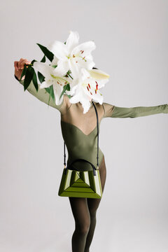 Modern Composition with Green Handbag, Elegant Outfit, and Flora