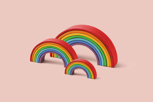 Stacked rainbow toys in three sizes on pastel background