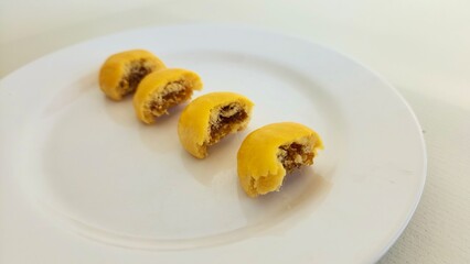 Pineapple Tart Cake that has been bitten on a white plate. In Indonesia, this cake is called nastar because the cake filling is pineapple jam, a popular dry cake in Indonesia during the Eid al-Fitr