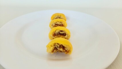 Pineapple Tart Cake that has been bitten on a white plate. In Indonesia, this cake is called nastar because the cake filling is pineapple jam, a popular dry cake in Indonesia during the Eid al-Fitr