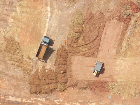Aerial Construction Site Truck Unloading Dirt Compactor