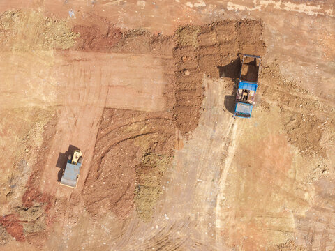 Truck Unloading Soil with Ground Compaction Machine