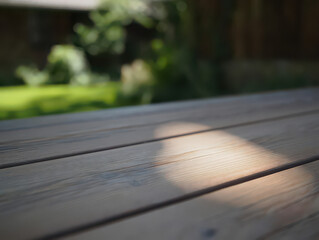Weathered Wooden Tabletop Bathed in Sunlight with Blurred Green Background