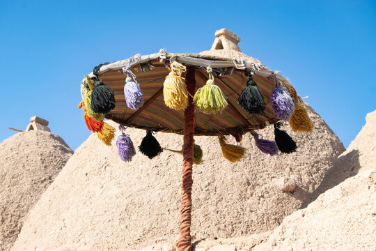 Colorful Parasol with Tassels in a Desert Village Under Blue Sky